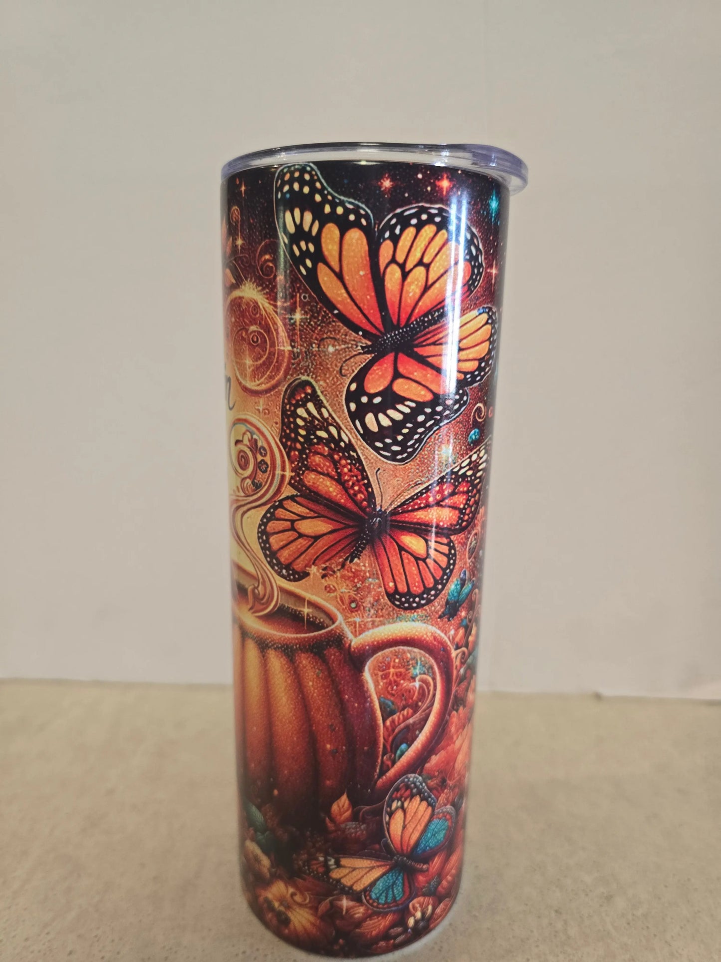 Tumbler with butterfly design on a plain background