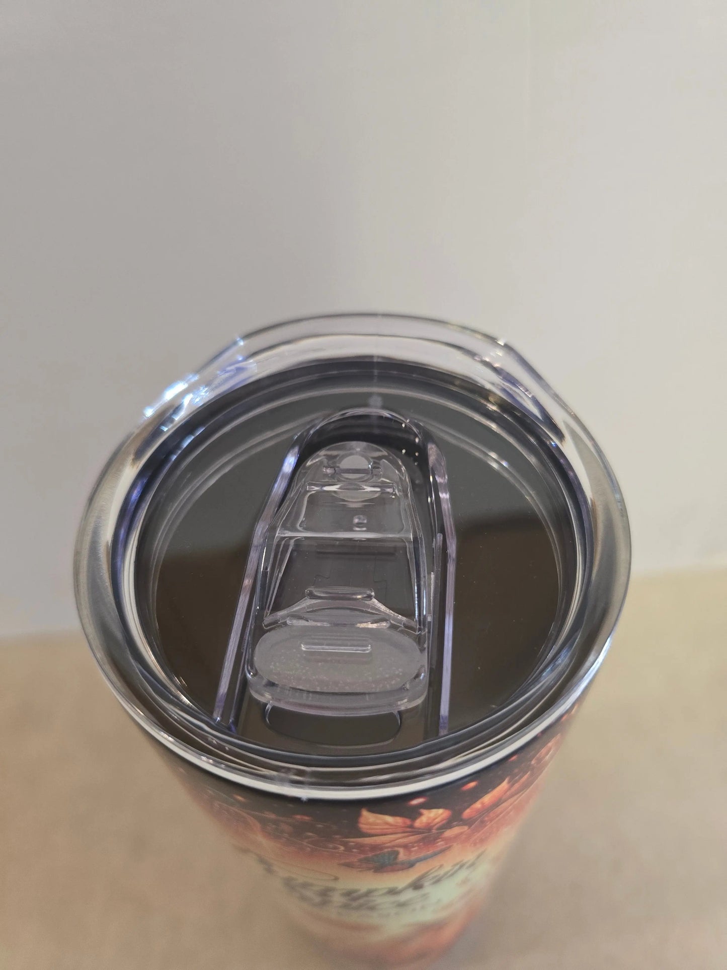 Close-up of a tumbler with a clear lid on a neutral background